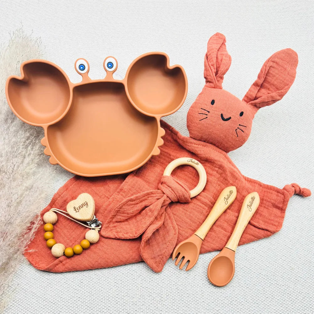 Set repas bébé personnalisé couleur terracotta, prénom Juliette et Lenny, coffret naissance complet avec assiette crabe silicone, couverts gravés, doudou coton, anneau bois prénom, attache tétine
