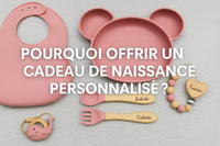 Coffret repas bébé personnalisé en silicone rose avec prénom gravé sur les couverts, bavoir, attache-tétine et jouet de dentition sur fond clair.