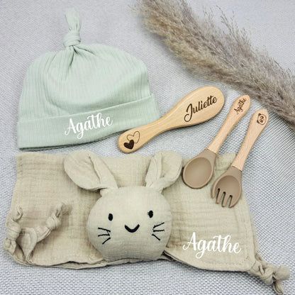 Coffret cadeau bébé fille Agathe avec bonnet vert pâle, doudou beige, brosse prénom Juliette et couverts gravés. Ensemble doux et chic.