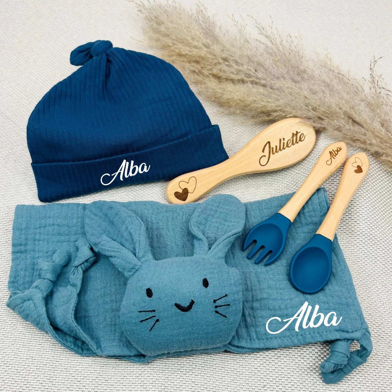Coffret naissance bleu personnalisé Alba avec bonnet en coton, doudou lapin bleu glacier, couverts et brosse gravés. Cadeau bébé garçon.