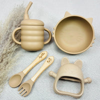 Coffret repas bébé complet beige en silicone avec bol chat, gobelet, jouet dentition et couverts gravés prénom Agathe. Ensemble parfait pour bébé.