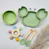 Coffret repas bébé vert pastel en silicone avec assiette crabe, bol tête d’ours, jouet sensoriel et couverts gravés prénom Gabin. Cadeau utile et mignon.