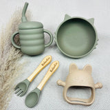 Set repas bébé en vert sauge et beige, avec prénom Valentin gravé sur couverts, bol chat et gobelet silicone. Cadeau pratique et sécurisé.