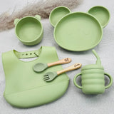 Set repas bébé vert clair en silicone avec prénom, assiette panda, bol, bavoir, tasse et couverts personnalisés en bois.