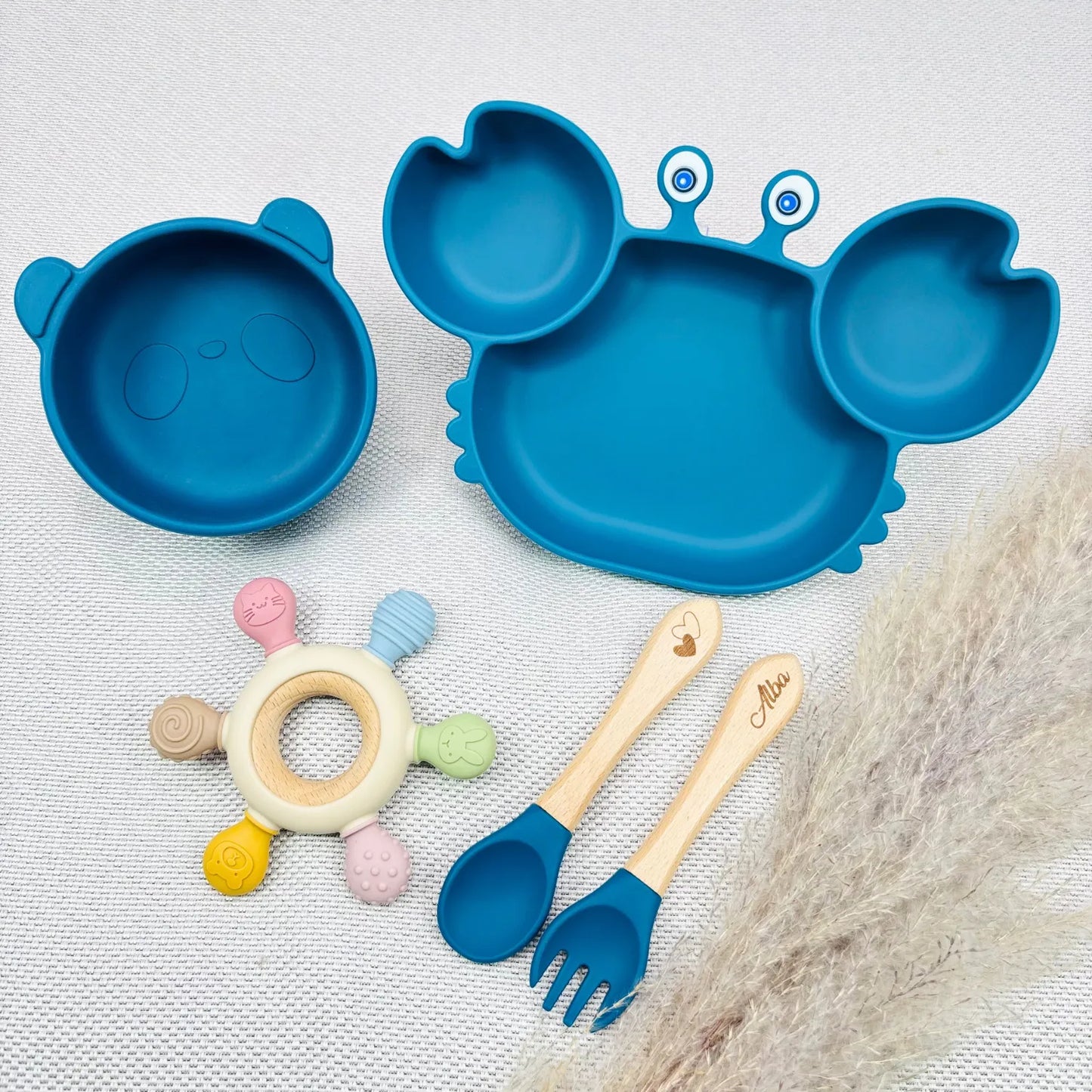 Vaisselle bébé bleu crabe avec bol ours assorti, jouet en bois/silicone et couverts personnalisés au prénom Alba. Coffret coloré pour repas bébé.