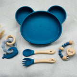 Vaisselle bébé bleue en silicone personnalisée avec prénom, assiette antidérapante, cuillère, fourchette et hochet.