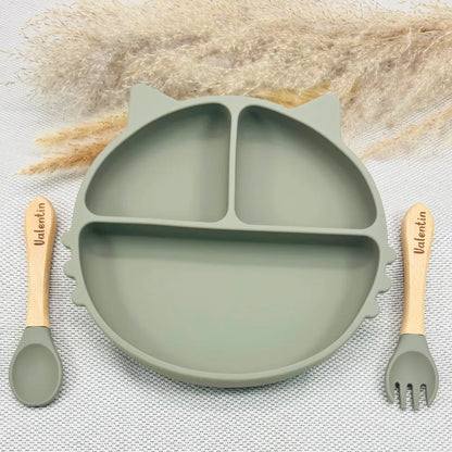 Vaisselle bébé vert olive avec prénom : assiette ventouse silicone et couverts bois. Idée cadeau naissance mixte.